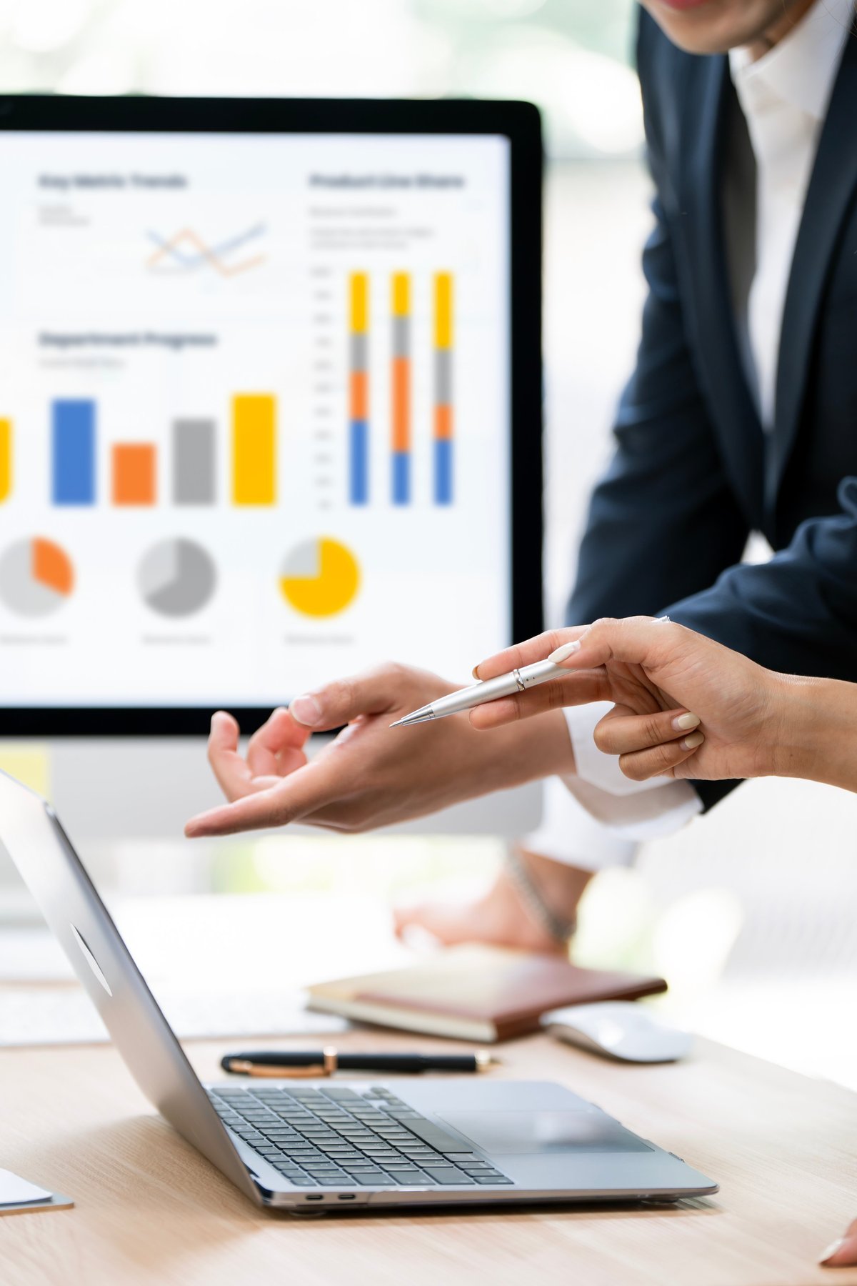 Financial advisors analyzing performance dashboards on a laptop